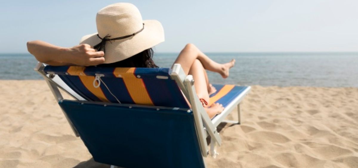mujer tomando el sol en la playa foto freepik