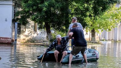 varios vecinos rescatan a una persona de avanzada edad afectada por la inundacion de una calle de jerson