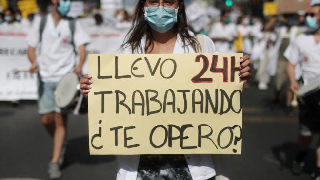 una mujer sujeta una pancarta en la que se lee llevo 24h trabajando te opero durante una manifestacion de los medicos internos residentes archivo